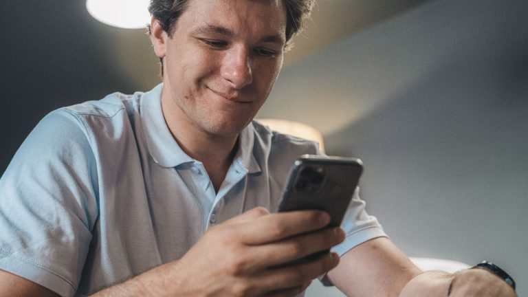 Cliente sorrindo ao ler uma mensagem no celular