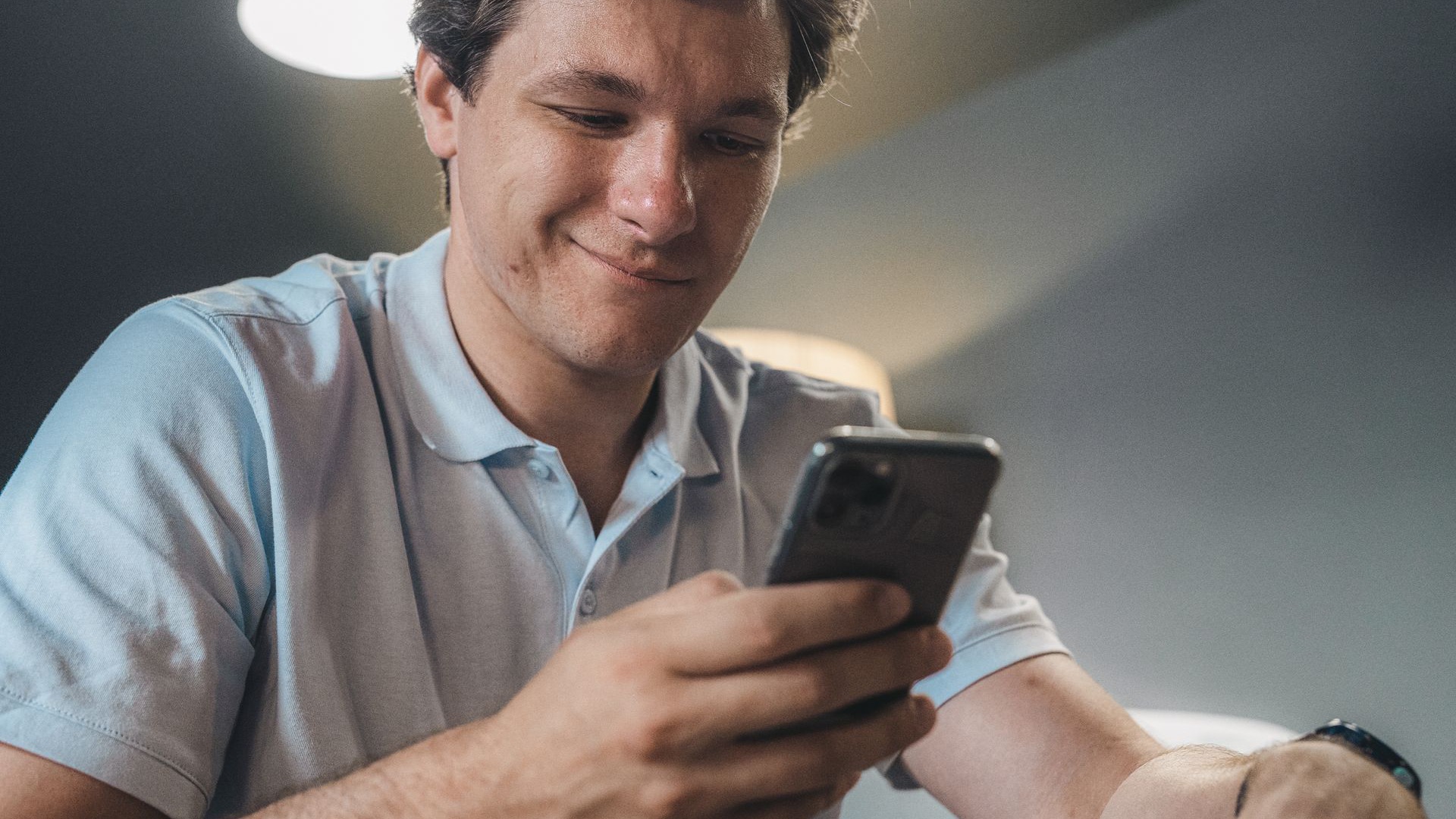 Cliente sorrindo ao ler uma mensagem no celular